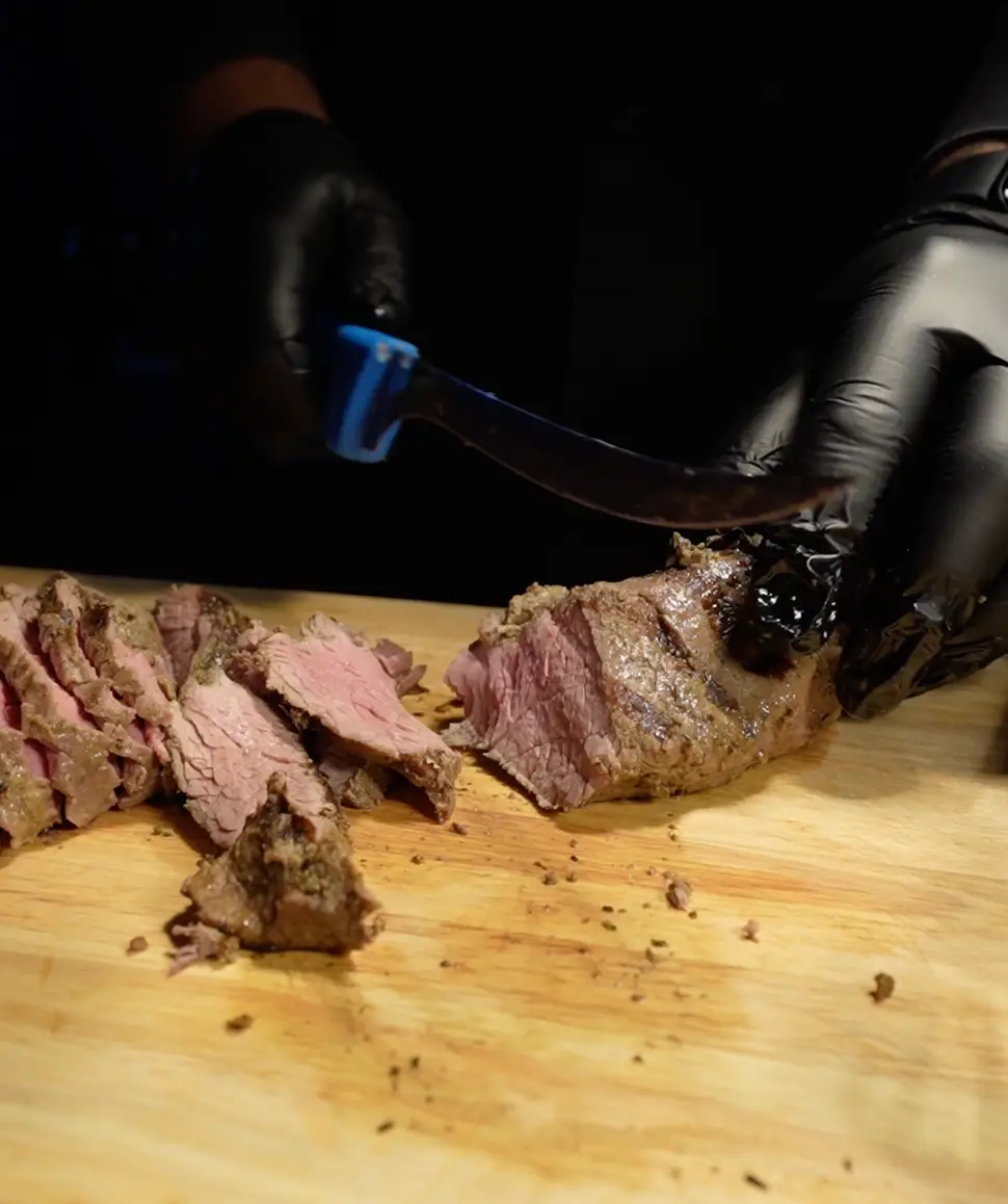Chef slicing roasted meat at a live carving station