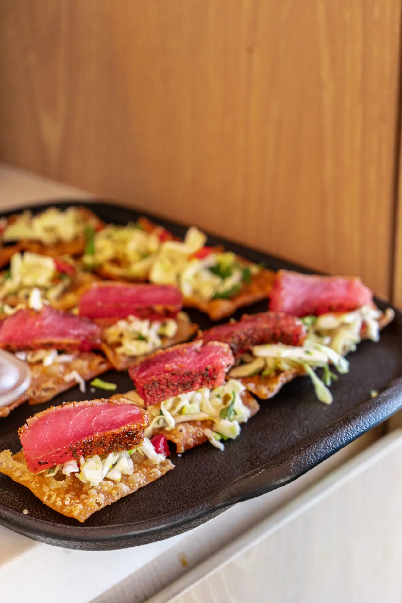 Seared tuna flatbread on a wooden board