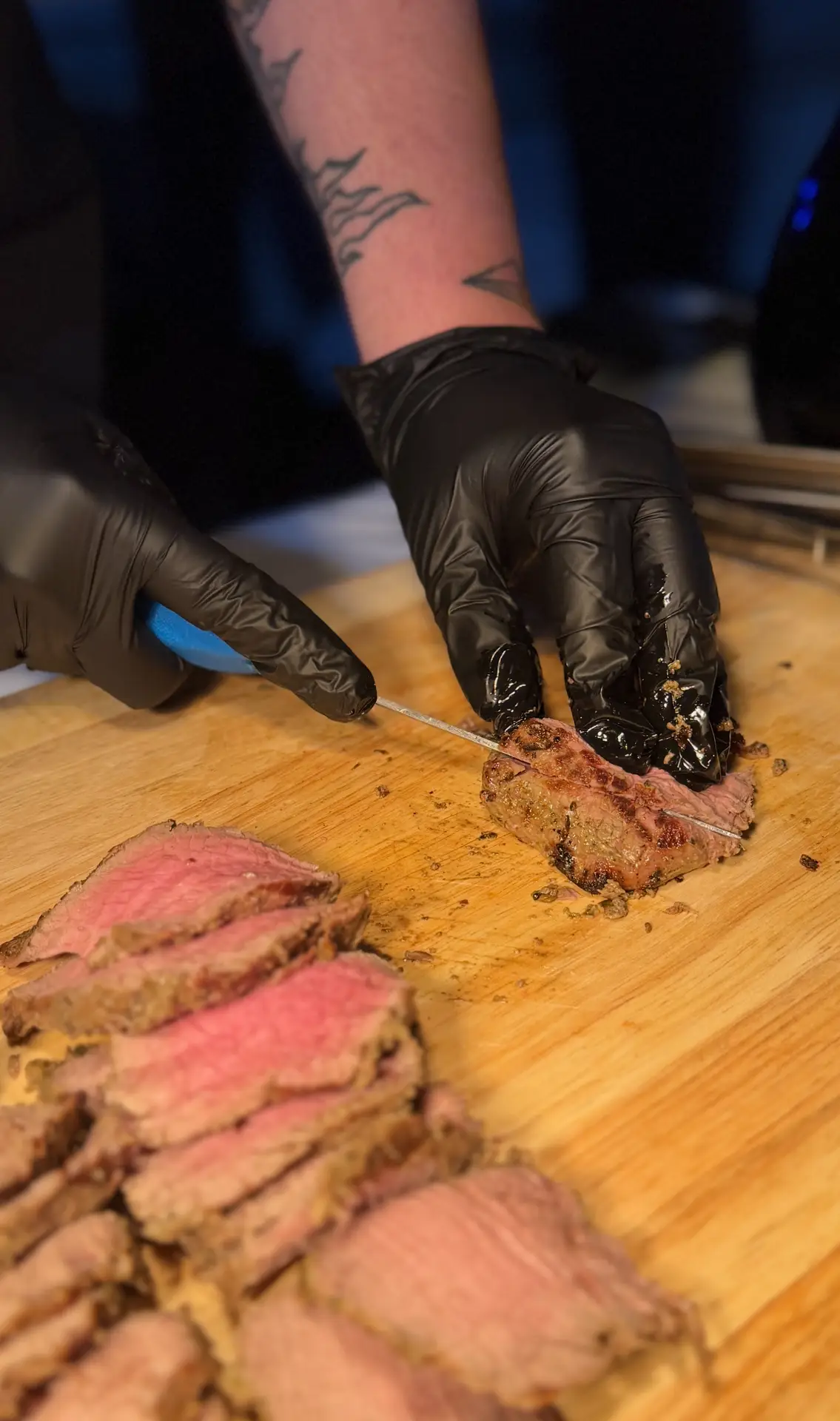 Chef hand-slicing steak at a carving station