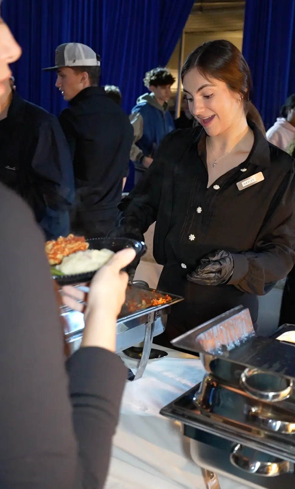 Top Shelf team member plating food for a guest at a catered event