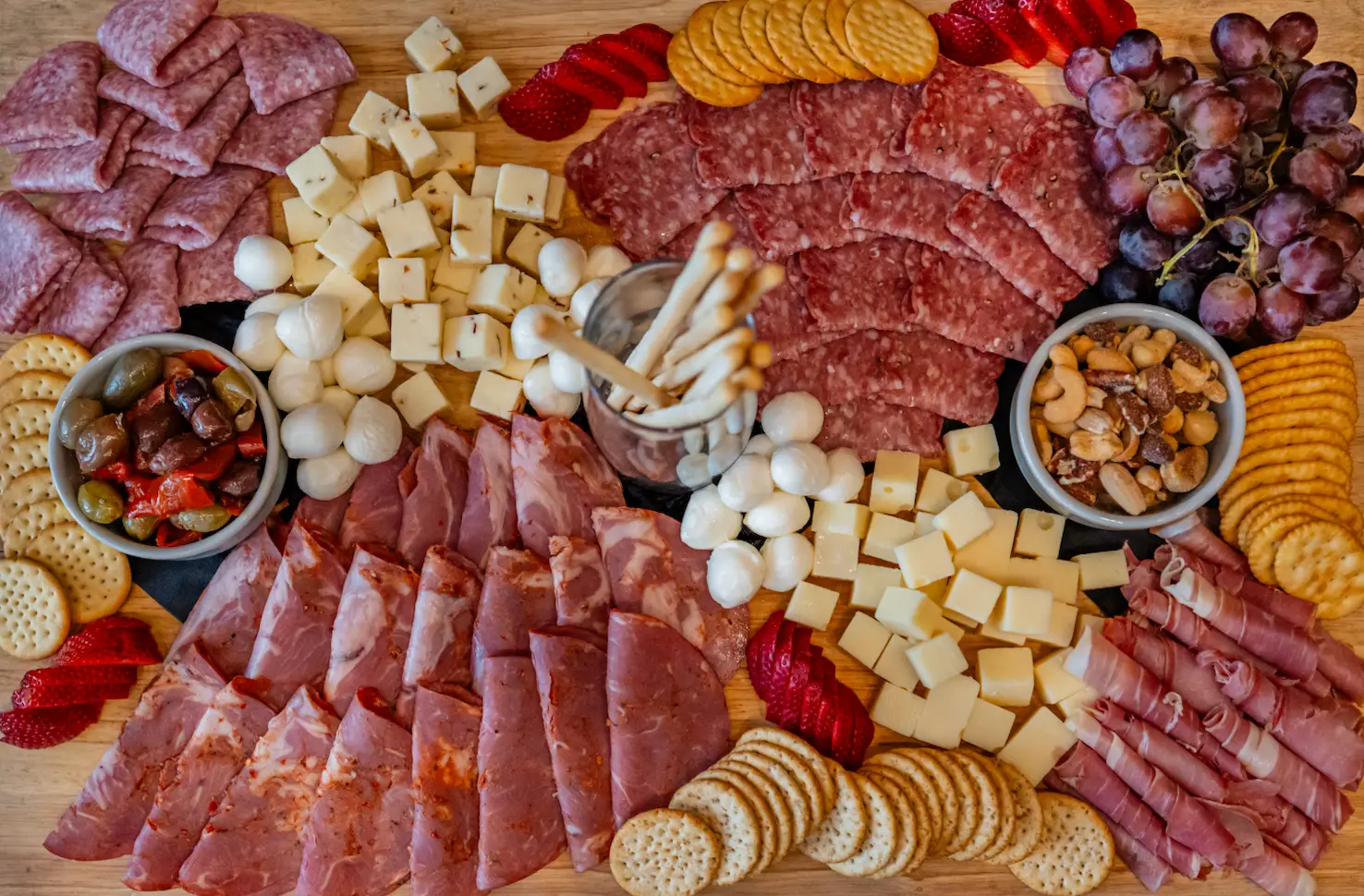 Charcuterie board with cured meats, cheeses, crackers and fruit