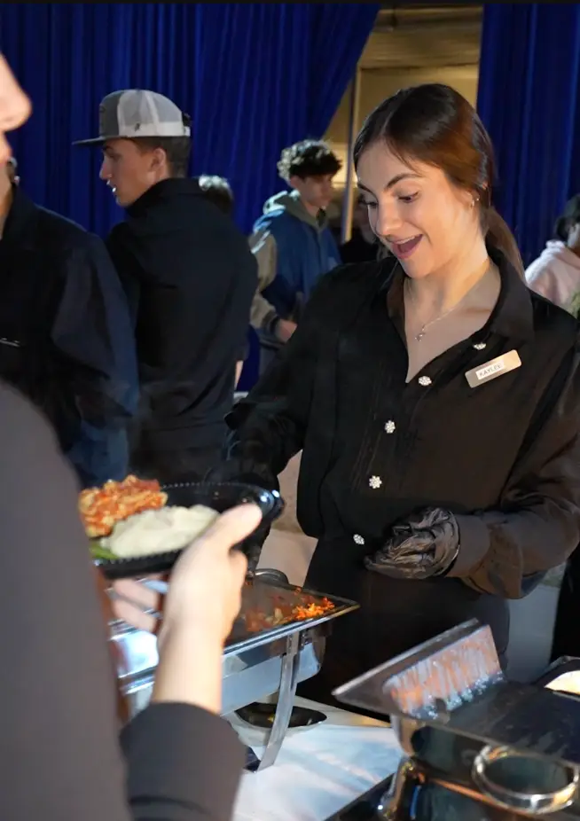 Top Shelf catering staff serving guests from a buffet line at an evening event in Tampa