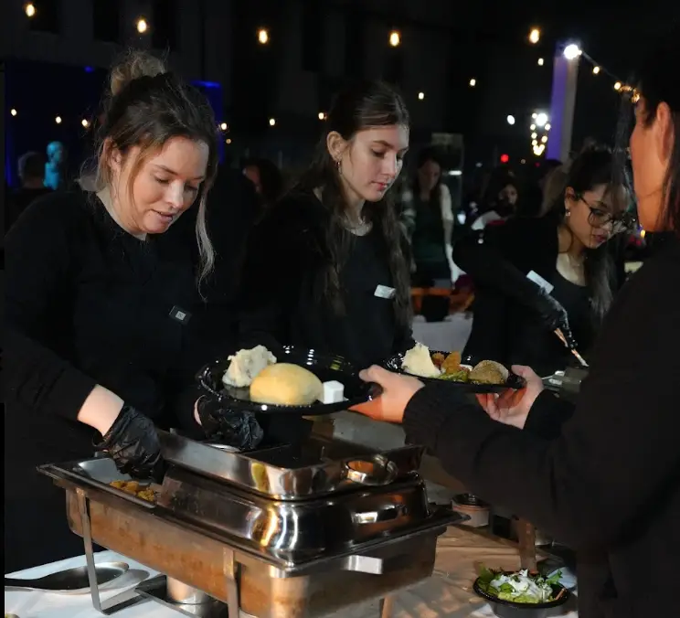 Guests being served from chafing dishes at an outdoor evening event in Tampa