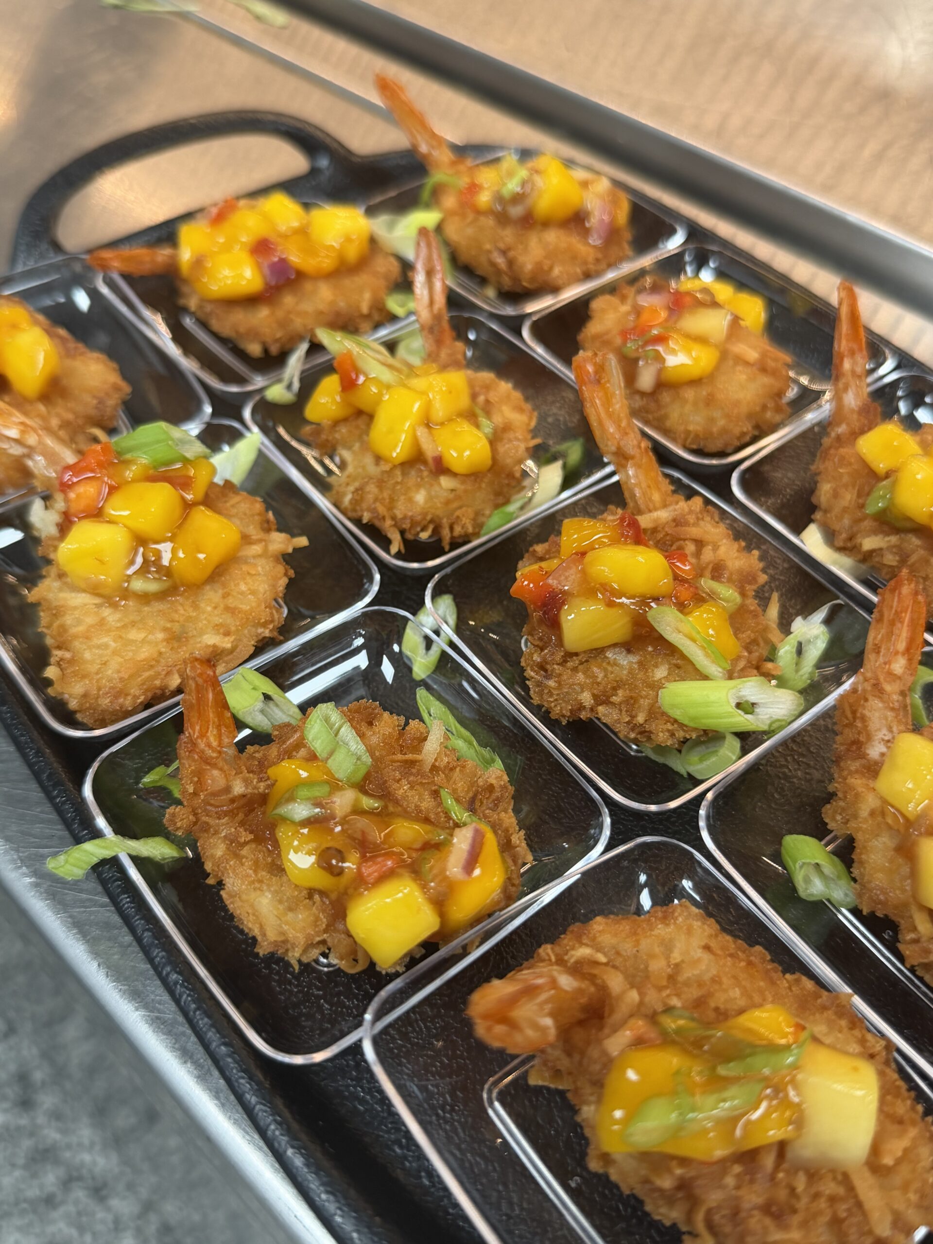 Coconut shrimp with mango salsa in catering trays